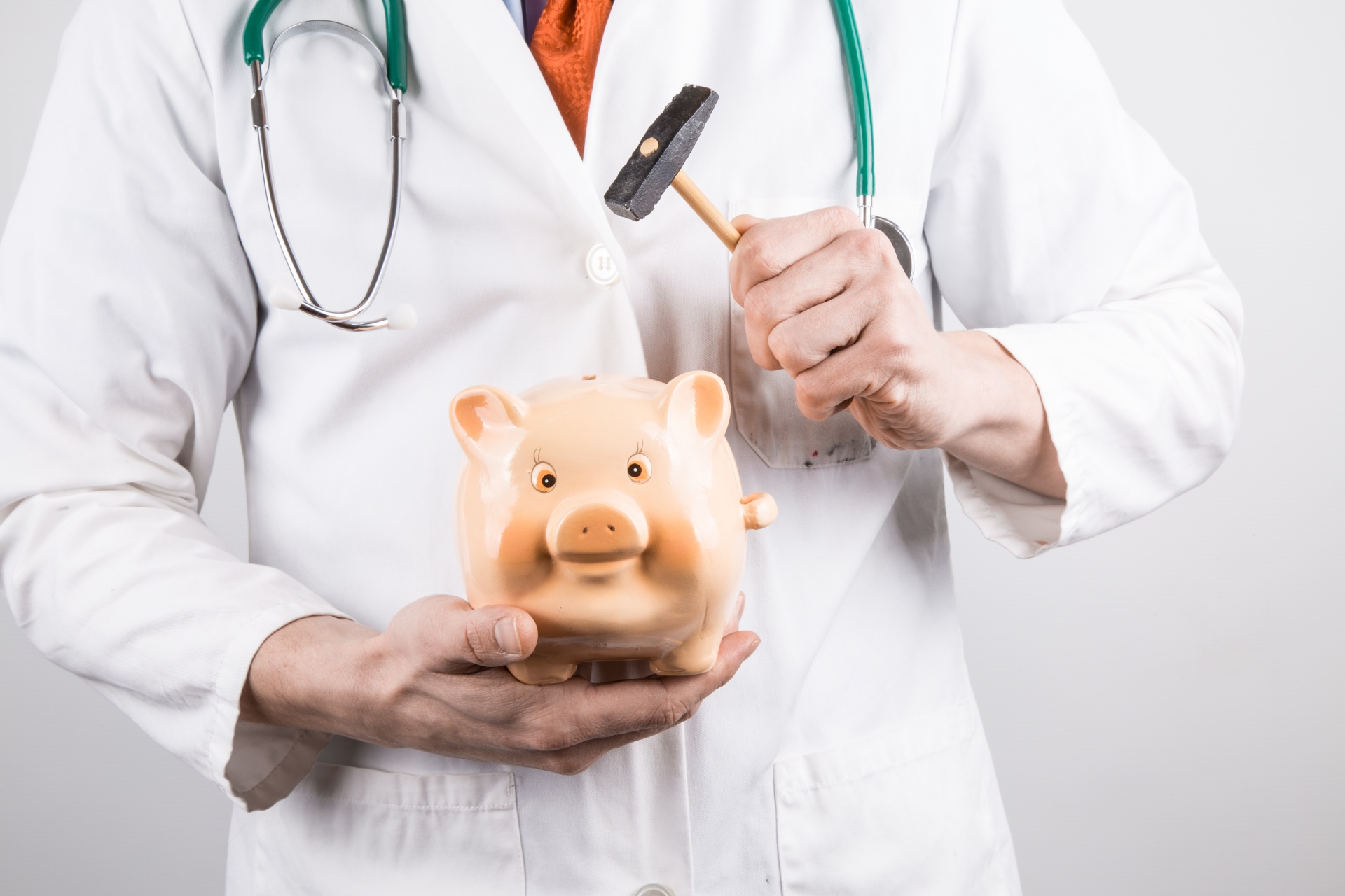 Doctor with piggy bank and hammer