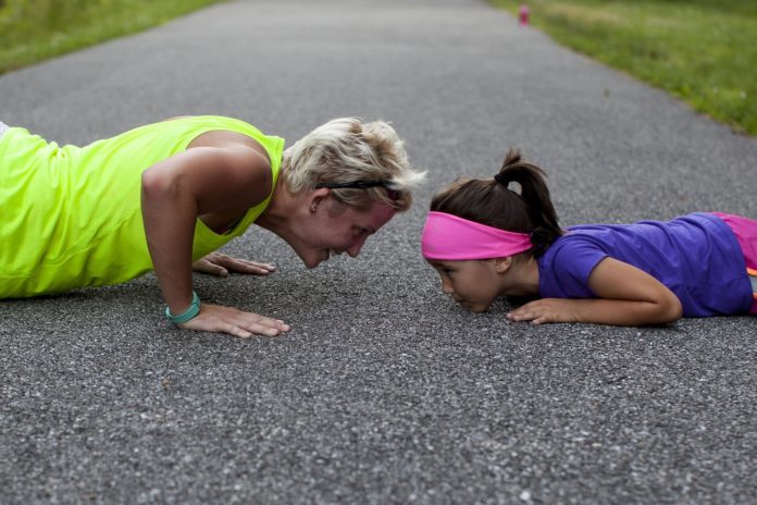 An Old woman does push ups with a kid