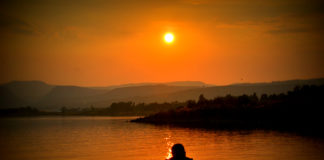 A traveler sitting and enjoying sunset