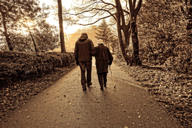 Old couple walking in park