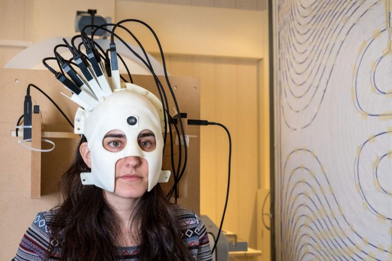 A handout photo showing a woman wearing a helmet brain scanner
