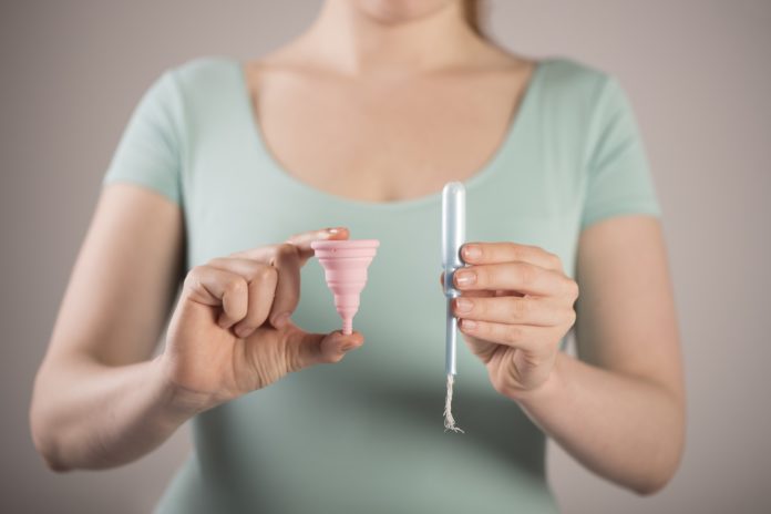 woman holding tampon and menstrual cup