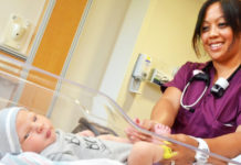 nurse examines a newborn