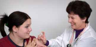 Girl receiving cervical cancer shot from doctor